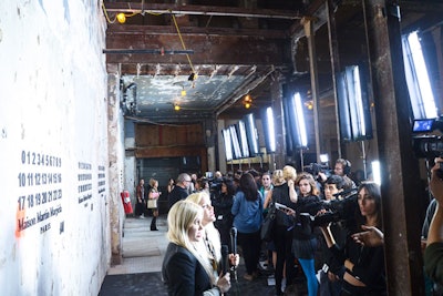 Housed on the main floor and illuminated by large spotlights, the event's step-and-repeat stamped Maison Martin Margiela's discreet trademark—the numbers 0 through 23—on raw concrete walls.