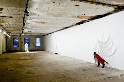 Known for his manipulation of physical space, American contemporary artist Daniel Arsham took over a quarter of the fourth floor with a piece that displayed the Margiela for H&M garments. Three figures—one draped, one standing, and one hiding—were 'imposed' into the surface of a custom wall, appearing to melt, erode, and ripple.
