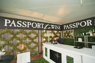 Constellations Brands' 'Passport to Wine' tent represented a departure from previous years. 'The brand has typically executed this space using rich leathers and mahogany,' said Wagner. 'This year they asked for something that wouldn't be too far off from the brand's [traditional image], but would bring a modern, luxe wine-bar feel.' To achieve that look, Wagner and her team used faux boxwood hedge as the backdrop and brought in silver mirrors on which servers wrote the featured wines of the day. Organizers accented the space with silver travel accessories such as chrome binoculars, lacquered books, and a model airplane.