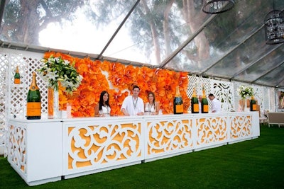 BrownHot Events partnered with Mille Fiori Floral Design to create an eight- by 20-foot paper flower backdrop for the V.I.P. tent bar.