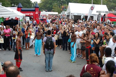 An acrobat troupe drew a large crowd on Saturday afternoon for its act, which incorporated comic tricks as well as flips and balancing feats.