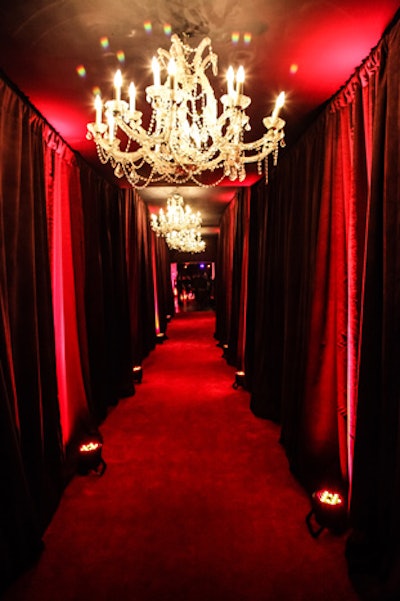 The main hallway of the Midtown West concert hall venue was redesigned with red carpet running the entire length of the passageway and floor-to-ceiling chocolate brown drapes punctuated by red up-lights. With five chandeliers hanging overhead, the hallway led to a red carpet and step-and-repeat where V.I.P. guests were photographed and interviewed.