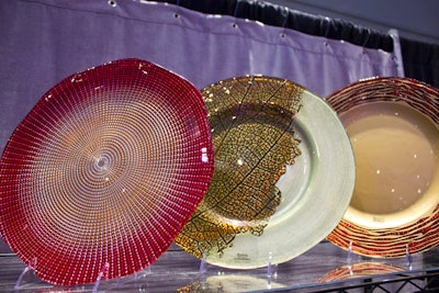 In addition to linens, BBJ showed off its newest glass chargers in a variety of colors and textures, including the holiday-appropriate Eternity dish in red-gold (pictured, far left).