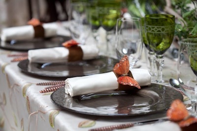 Custom butterfly napkin rings and leafy overlays enhanced the theme.