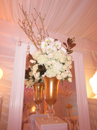 White flowers and golden branches sprouted out of large vases.
