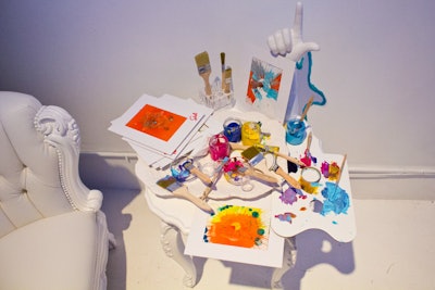The event provided guests with paintbrushes and paint; the tools were scattered around the space on tabletops and other surfaces.