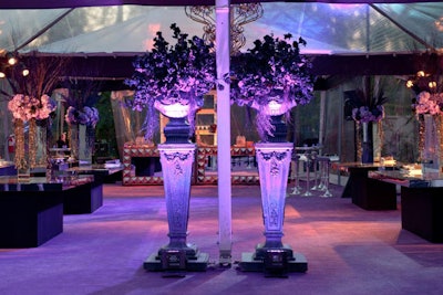 Purple uplighting from Kinetic Lighting provided an eerie glow for the flowers from Sticks & Stones. The flowers stood in urns atop tall pedestals.
