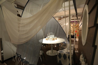 Carnegie's table, designed by Gensler, had a nautical theme. The table was surrounded by sails and was topped with rope-tied vases holding water and live fish. From the show floor, guests peeked into the vignette through a circular window reminiscent of a ship portal.