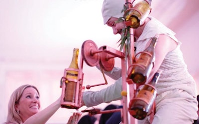 Chicago-based Redmoon Theater’s annual benefit in March had a performer topping off guests’ glasses with the company’s “Wine Bike,” which features a spinning chandelier of wine glasses and a series of gears that pour bottles of wine.