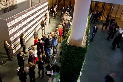 To separate the red carpet from the check-in desk, MoMA's in-house team used more than 150 running sheets of boxwood hedging to create a 10-foot-tall, leafy divider. With no flowers in the rest of the space, the greenery gave the entrance a more intimate feel.