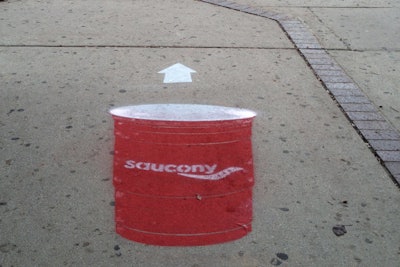 Planners from C3 used washable spray paint to deck downtown sidewalks with images of red Solo cups; arrows pointed toward the Saucony event.