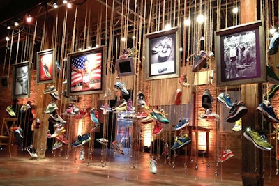 An art installation told the history of the Saucony brand. The piece included shoes hanging from jute rope, fishing weights, wood, and iPads in weathered frames.
