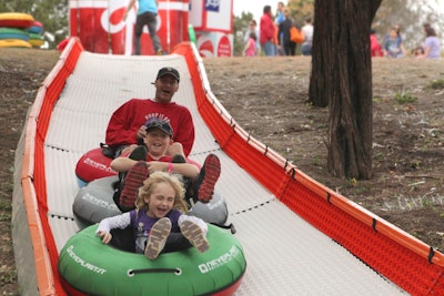 Using inner tubes, families sled down the 200-foot-long tobogganing run created by J.C. Penney as part of its Holiday Giving tour campaign in Dallas.