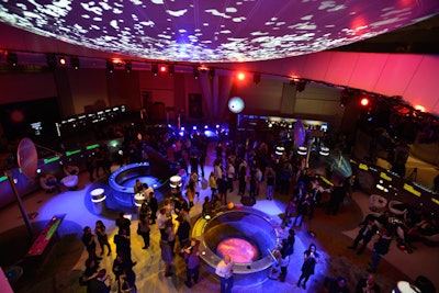 In contrast to the stark checkpoint, the main space for the event was heavily saturated with bright pink, blue, and purple lighting. The organizers also added modern white furniture to the hall.
