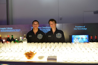 Staffers in military flight jumpsuits with the A.A.S.A. branding and backlit bars decorated with images of stars and galaxies advanced the space academy concept.