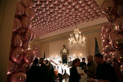 In the music room, hundreds of mylar balloons were strung across the ceiling and along the walls to create an elegant yet festive cocktail party atmosphere. The chandelier and wall and curtain treatments were preexisting elements, while all furniture was brought in.
