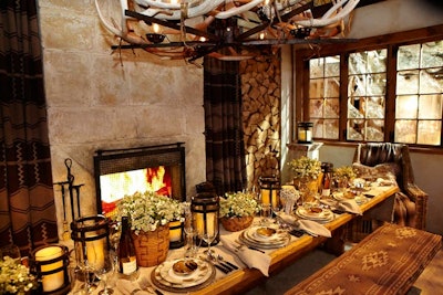 At Diffa's Dining by Design in New York, Ralph Lauren went with a cozy, ski chalet-inspired look. Centerpieces of snowberries and wrought-iron lanterns created a runner down the center of the rustic wood table. Other striking details included a faux fireplace, Pendleton-inspired bench cushions, and an antler chandelier.