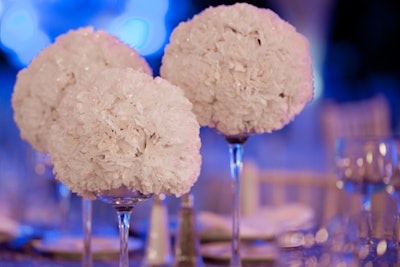 Centerpieces of white carnations designed by Feats Inc. evoked fluffy snowballs.