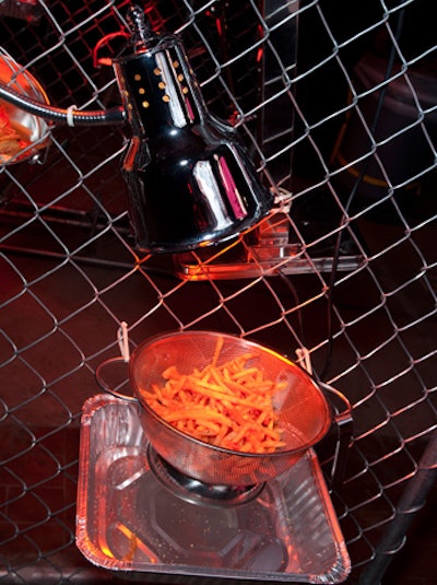 Near the entrance, onion rings and French fries hung in colanders attached to chain-link fences. Guests used hanging tongs to transfer the fried snacks into paper cones.