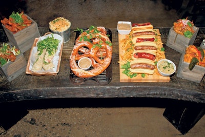 Mac ’n’ cheese; chicken wings served with assorted sauces; kielbasas; Bavarian pretzels; and grilled chicken Caesar salad wraps, by the Garden at Studio Square NYC in New York