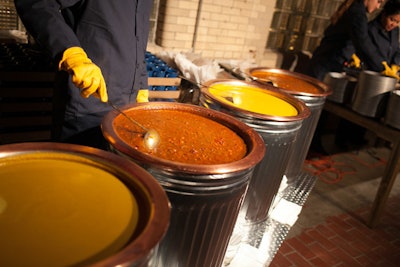 Servers wearing rubber gloves and navy-blue factory uniforms served butternut squash soup and chili from trash cans. The serving vessels were tin mugs.