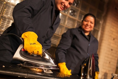 At a panini station, attendants used irons and an ironing board to toast ham-and-cheese and tomato-and-cheese sandwiches.