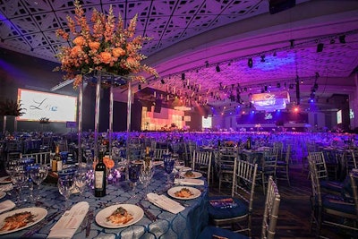 Fox Ventures designed a mix of tall and shorter centerpieces all using orange and white flowers accented by votives around the base.