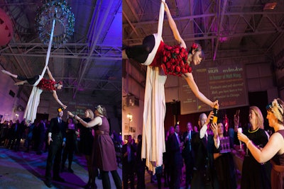 Dubbed the 'champagne chandelier,' a chandelier-like piece dripping with bottles and stemware hung 25 feet above the crowd. An aerialist descended from the center of the fixture on long swaths of silk and poured bubbly into guests' flutes below.