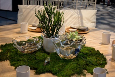 Kenneth Cobonpue's table was enclosed inside a sort of wicker birdcage. At the center of the organic wooden table was a mound of moss topped with bowls that held live Betta fish; directly above was a chandelier composed of glass jars holding faux fireflies.