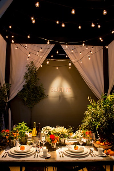 The table Frette designed for The New York Times was housed inside a black-and-white striped cabana. With rustic wood accents, fresh oranges, and arrangements of olive tree branches, the tabletop had a Tuscan countryside vibe.