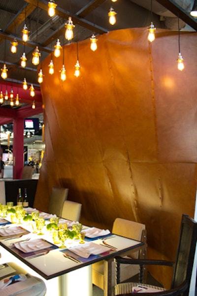 The table by Rottet Studio and Morgans Hotel Group displayed leather walls, exposed lightbulbs, and dishware that resembled curled-up book pages.