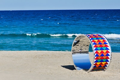 As part of the decor, event planners situated oversize Hermès enamel bracelets on the beach for an added touch of whimsy. Complementing the bracelets were items like an orange sorbet trunk in Hermès orange and Hula-Hoops wrapped in Hermès silk scarf prints.