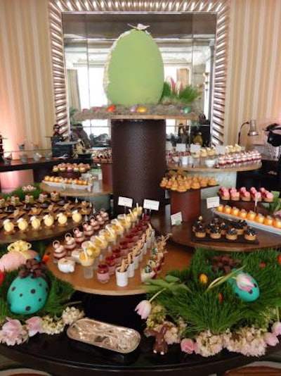 The Peninsula Chicago is gearing up for its big Easter brunch on Sunday, which has the theme 'Around the World in 80 Days' and will feature everything from sashimi to passion-fruit coconut cake. Last year's brunch (pictured) had an 'Alice in Wonderland' theme. The sweets station held cupcakes, macarons, cotton candy, assorted tarts, and more. A giant, mint-green egg topped the station.