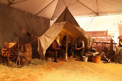 For the contemporary Western show Hell on Wheels, a small tent town was erected in the middle of a simulated sunlit plain. Guests walked about the campsite, peeking into the tents to observe the railroad workers. All of this took place as guests made their way across a central pathway where a cowboy sat atop a split-rail fence strumming his guitar.