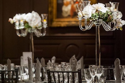 The candelabras on each table held an unusual floral combination of white orchids and succulents—a combination of the masculinity of the room and femininity of the white flowers and linens.