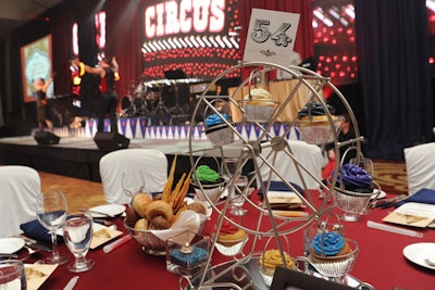 Dinner tables were topped with miniature Ferris wheels that held cupcakes topped with colorful frosting.