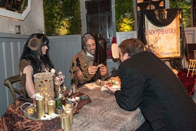 Costumed entertainers, including fortune tellers or 'soothsayers,' were set up at stations around the space.