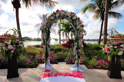 Floral arch bookended with floral pedestal bursts