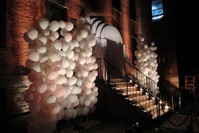 In keeping with the night's prom theme, six large stanchions of white balloons—branded with Target logos and up lit with spotlights—were erected at the entrance to the party venue with dramatic effect. A custom canopy, covered in the 'Kate Young Target' logo, was built at the base of the doorway. A total of 1,000 balloons were used outside.