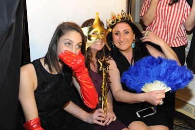 Evoking a child's dress-up box, a photo booth had props including royal crowns, feathery fans, and star-topped wands.