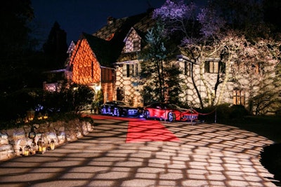 Ferrari and Maserati automobiles flanked the entrance of the Italian Embassy, known as Villa Firenze, and a patterned projection designed to show off the home's architecture lit the front of the residence.