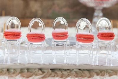 At a dessert table from Sugar Chic Designs, pink macarons were displayed on dainty, miniature ghost chairs.