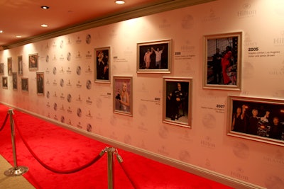 Custom step n' repeat wall with 3 dimensional framing and details. Custom branded red carpet, lighting and rope and stanchions.