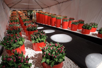 Landscape architect Maria Smithburg and Manifredini Landscaping & Design lined the entrance with red buckets of varying heights. The buckets held lush, cheerful arrangements of purple tulips.