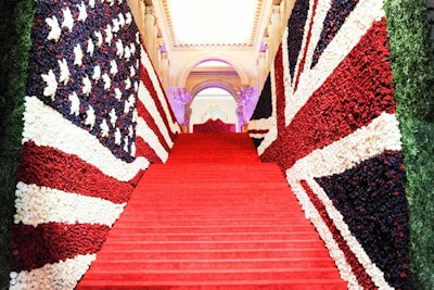 The staircase was flanked by oversize American and British flags made entirely of 150,000 red, white, and blue roses, designed to represent the punk movement's origins in New York and London. One hundred models dressed as punks later lined the steps, kitted out in ripped and torn regalia complete with spiked and dyed wigs by Redken creative consultant Guido. At the top of the staircase, past a series of sculptures underlit with rosy hues, pink-lit cherry-blossom trees, and pink fiberglass planters, was the receiving line, where the co-hosts received guests against a hedge wall of pink roses.