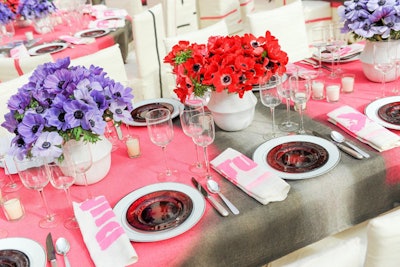 The 80 dining tables were covered in custom tablecloths (the undercloth was linen, the overcloth was burlap) spray-painted in a pink, black, and white graffiti motif. Centerpieces held anemones in bright colors, while the dais was custom-made and whitewashed. Avila's team also made table number card holders out of two large six-inch safety pins, which were welded together. The napkins were hand-printed with the word 'Punkature.'