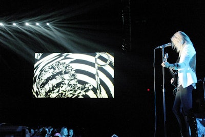 Against large projection screens measuring 33 by 19 feet and 29 by 16 feet that flanked the visible backstage played pretaped Versus inspiration videos as guests initially arrived. During the performances, the screens stimulated guests with a video loop of psychedelic black-and-white imagery in motion.