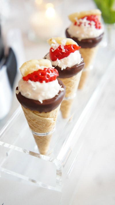 Chicago’s Truffleberry Market reports recently receiving requests to create finger-friendly versions of classic desserts. The catering company's banana split cones feature strawberry mousse in a mini waffle cone dipped in dark chocolate and topped with fresh strawberries, banana chips, and shaved hazelnuts.
