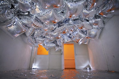 About 200 gigantic Mylar balloons filled one of two 'aluminum play rooms' that guests encountered in a long hallway before entering the main party space. The other play room featured strobe lights, blowing fans, and confetti.