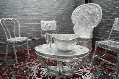 To play up the idea of metal, all the furniture was hand-wrapped in traditional kitchen aluminum foil 'to give a new look to traditional things,' said Bureau Betak founder Alex de Betak. Forty pounds of Mylar confetti covered the floor, and the brick walls were painted silver and purposefully left unfinished.